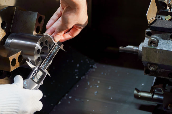 Engineer measures CNC machine component