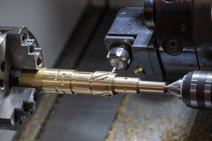 Brass being cut to size during CNC machining