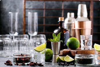 Cocktail shaker, glasses, and fruit for making tequila cocktails